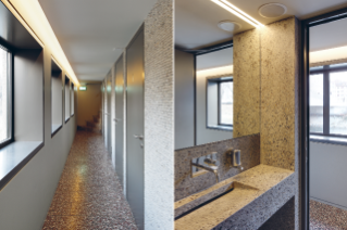 Beton in verschiedenen Bearbeitungszuständen: Terrazzoboden und Wand aus gestocktem Beton / Geschliffene Betonwände in den WCs (© Beat Bühler, Zürich)
